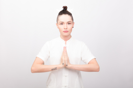 fitness, sport, training and lifestyle concept - Young woman doing yoga exercise. Young Woman praticing tai chi chuan in the gym. Chinese management skill Qi's energy.の写真素材