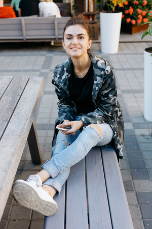 People, beauty, fashion, lifestyle and color concept - Outdoor full body portrait of young beautiful happy smiling girl posing on street. Model looking at camera. Lady wearing stylish clothesの写真素材