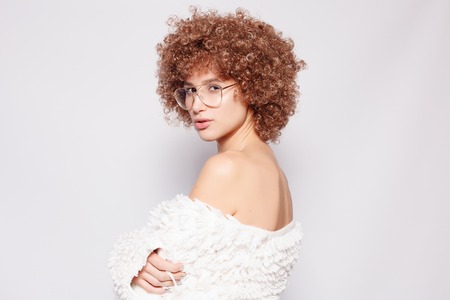 Portrait of smiling young black woman. Portrait of a beautiful young woman with African American afro haircut and glamor makeup. Studio shot. Attractive girl wearing eyeglasses.の写真素材