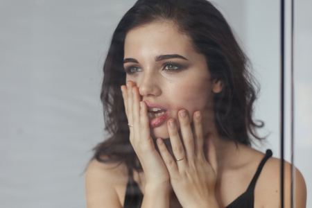 Screaming Angry Woman Sitting on Couch at home. Negative thoughts. Poor stressed woman sitting on the bathroom. Portrait of a frustrated angry woman screaming out loudの写真素材