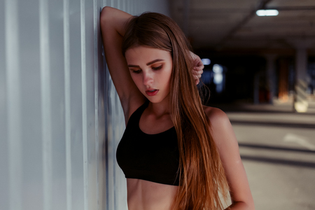 Relaxed young sportswoman standing outdoors and smiling. Slim female athlete after workout in morning.の写真素材