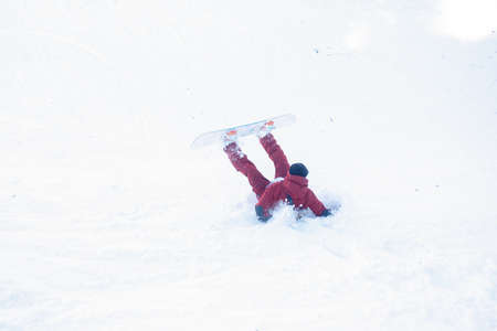 winter, leisure, sport and people concept - Man snowboarding in the mountains. Snowboarder resting on mountain top on a background of blue sky. Ski resort.の写真素材