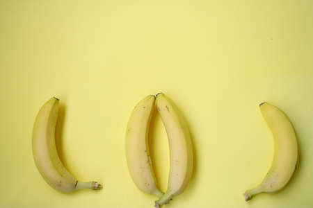 Fresh Banana on yellow background. Seamless pattern with bananas. Tropical abstract background. Banana on yellow backgroundの写真素材