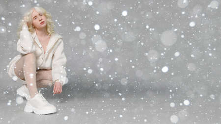 snow, winter, christmas, people, beauty concept - beautiful albino girl with white skin, natural lips and white curly hair wearing stylish white sweater, copy space, beauty. 16: 9 panoramic format.の写真素材