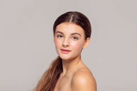 health and beauty concept - Beautiful Young Woman with Clean Fresh Skin touch own face. Facial treatment. Cosmetology, beauty and spa.の写真素材