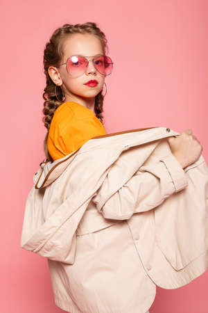little girl in pink glasses. Trendy fashion style stylish funtime concept. Vertical full-size...