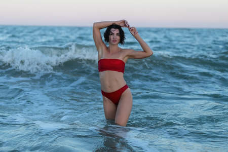 Summertime recreation concept. Beautiful young sexy woman with fit trained slim body wearing red...