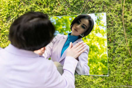 Summer Girl in a white dress and hat with a mirror in nature. The concept of relax, travel, freedom and summer vacation. Fashion style.の写真素材