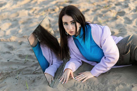 Summer Girl in a white dress and hat with a mirror in nature. The concept of relax, travel, freedom and summer vacation. Fashion style.の写真素材