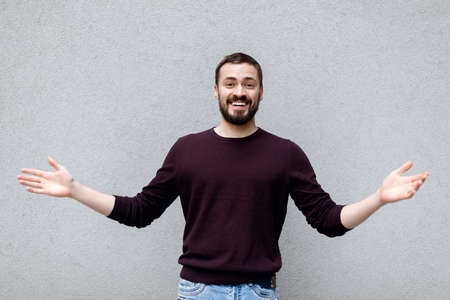 Close up portrait of smiling handsome man in white t-shirt looking at camera, isolated on gray backgroundの写真素材