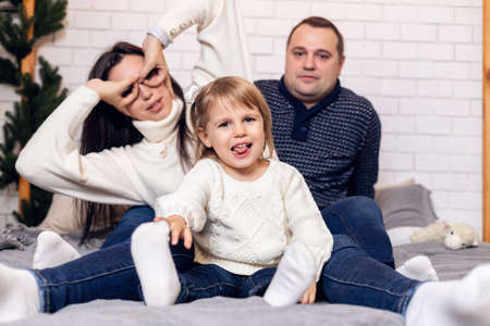 Merry Christmas and happy holidays Parents and young baby daughter girl have fun and play together...