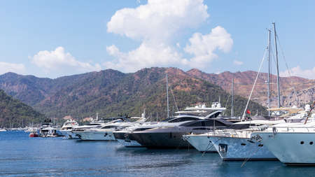 Yacht club and marina long view. Luxury yachts docked in sea port at sunset. Marine parking of...