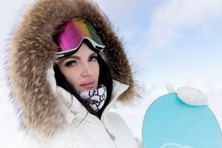 winter, leisure, sport and people concept - Close-up Portrait Beautiful Model Woman wearing a Snowboard Mask on her Head. Pretty young woman having winter rest outdoorの写真素材