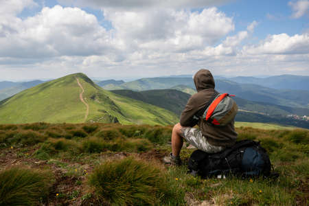 Man solo traveling backpacker hiking in scandinavian mountains