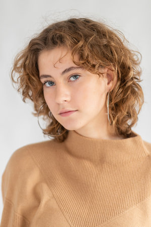 Portrait beautiful woman face close up portrait young curly hair studio on grayの写真素材