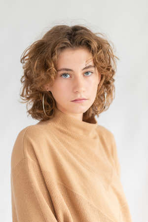 Portrait beautiful woman face close up portrait young curly hair studio on grayの写真素材