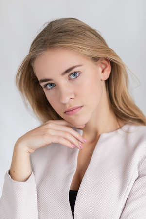 Confident good-looking beautiful woman with blonde dyed hair with healthy pure skin dressed in casual clothes looking seriously at camera. youth and beauty conceptの写真素材