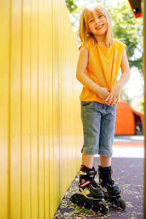 Indoor picture of playful energetic active little girl raising hands, sitting on floor isolated over...