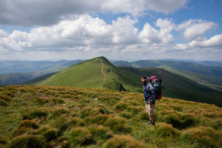 Man solo traveling backpacker hiking in scandinavian mountains active healthy lifestyle adventure journey vacationsの写真素材