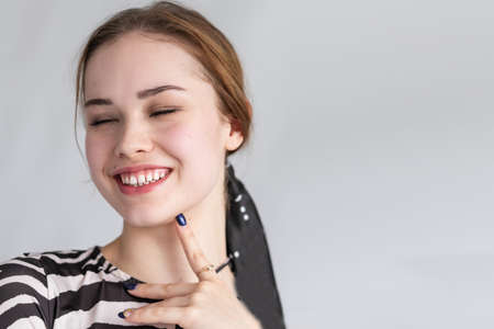 people, luxury and fashion, emotions concept - The young woman's portrait with happy emotions, smile , Closeup of beautiful brunette woman with pretty eyes and gap between teethの写真素材