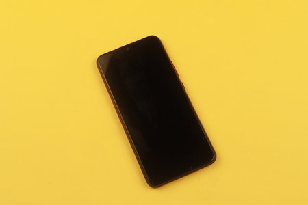 Smartphone on a yellow background with copy space. Design, Fine Art, Minimalism