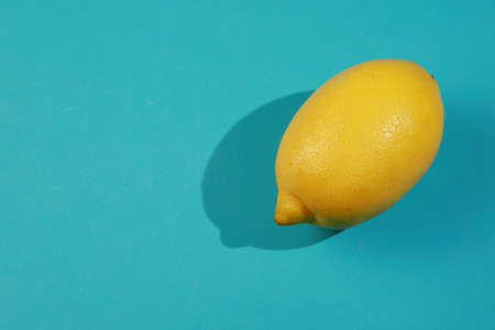 yellow lemon on a blue background with copyspace. Design, Fine Art, Minimalism