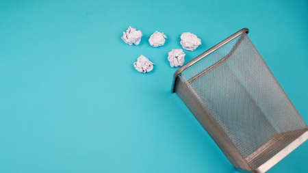 Heaps of rubbish are thrown out of the trash bin. For copy space for designers on a blue backgroundの写真素材