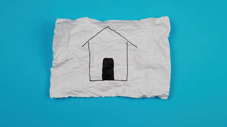 a crumpled white A4 sheet with a house drawn on it. The concept of a dream of your own home.の写真素材