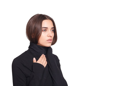 Exude grace and charm with a portrait of a beautiful middle-aged woman, her brunette locks framing her face as she poses confidently in a contemporary turtleneck.の写真素材