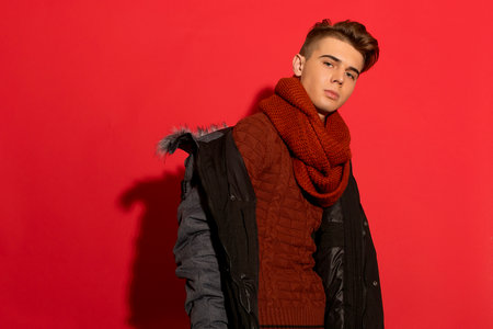 Make a statement! Stylish guy in a jacket pops against a fiery red background, adding flair and personality to any composition.の写真素材