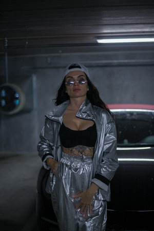 Fashion-forward woman showing her enviable figure in a metallic ensemble, effortlessly complementing...