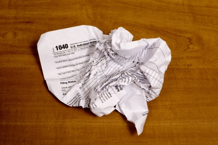 Crumpled Tax Form on a Wooden Backgroundの写真素材