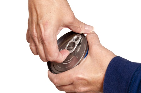 A mature woman trying to open a food can の写真素材