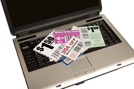 A laptop with coupons on top represents online coupons  XXXLの写真素材