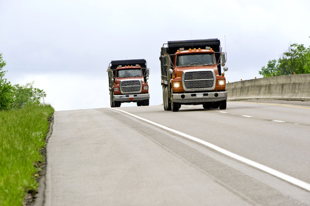 Two Dump Trucks On Highwayの写真素材