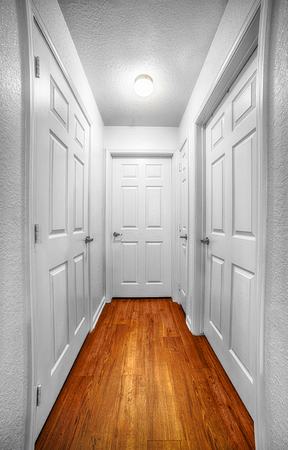 Vertical shot looking down a hallway with four doors.の写真素材