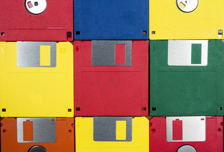 Horizontal close-up shot of nine multicolored plastic diskettes.  Shows fronts and backs of disks.の写真素材