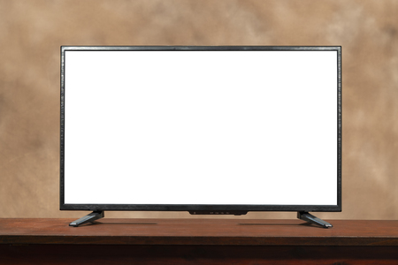 Horizontal shot of a blank large screen tv with copy space on table.  Brown muddled background.の写真素材