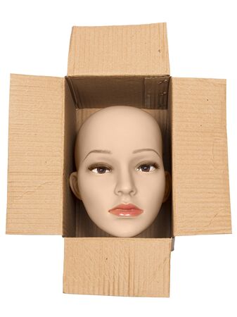 Vertical shot of a bald woman mannequin head inside an open cardboard box. White background.の写真素材