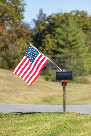 Vertical shot of a mailbox flying an American Flag.の写真素材