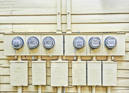 Horizontal shot of electricity meters mounted on the wall of a family residential structure.の写真素材