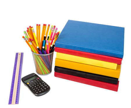 Horizontal shot of a group of school supplies which include a stack of colorful books laying on...