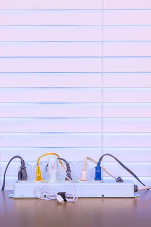 Vertical shot of a desktop power strip full of plugs with copy space.