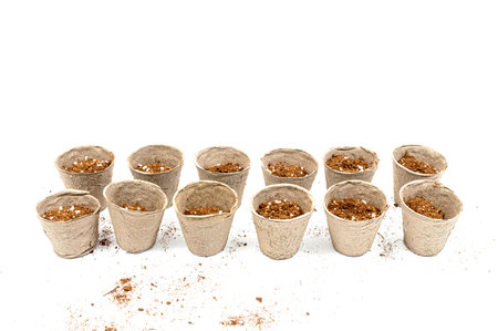 Horizontal shot of peat pots with soil against a white background with copy space.の写真素材