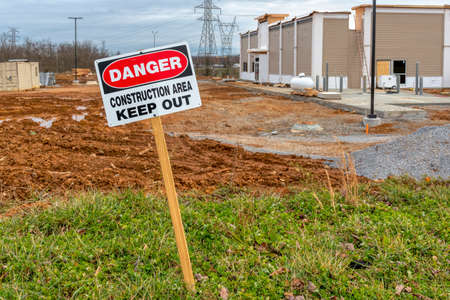 Horizontal shot of a Danger Construction Area Keep Out sign next to a fast food restaurant under construction.の写真素材