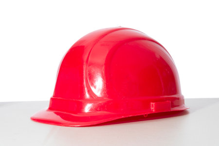 Horizontal shot of an old red hard hat with shadow and copy space.  White background.の写真素材