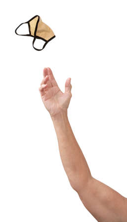 A hand pitching a used Covid face mask away, isolated on white with copy space.の写真素材