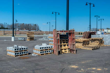 Horizontal shot of cinder blocks, scaffolding, and wooden pallets at an industrial construction...