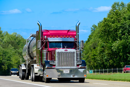 Knoxville, Tennessee, United States â August 20, 2024: Horizontal shot of an eighteen-wheel fuel transporter on a Tennessee interstate. Heat waves rising from the hot asphalt creates a blurring effect on background trucks and foreground pavement.のeditorial素材