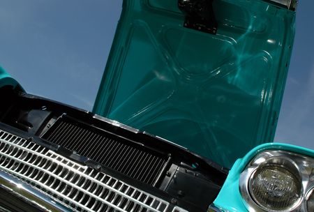 turquoise classic car with hood up